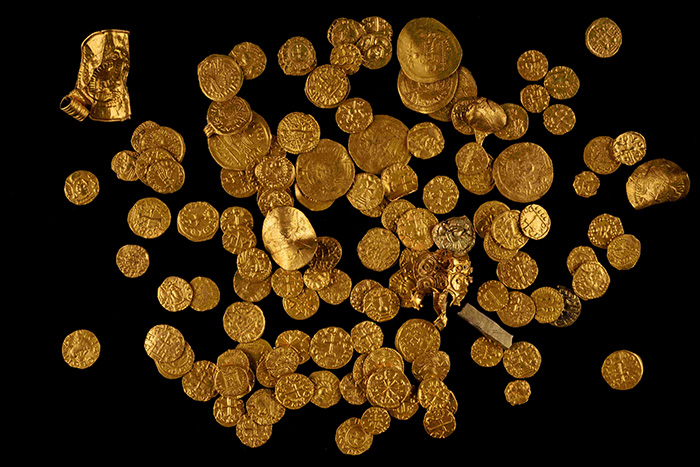 Many gold coins on a black background