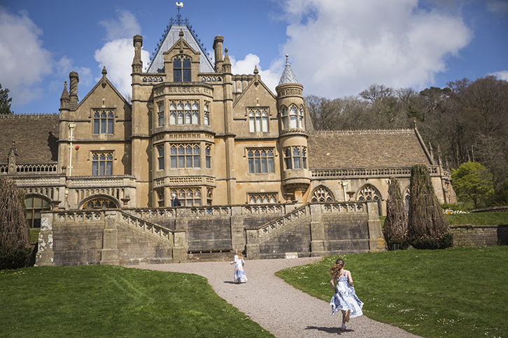 Two children running towards grand house