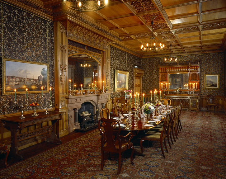 A dining room with table set and candles alight