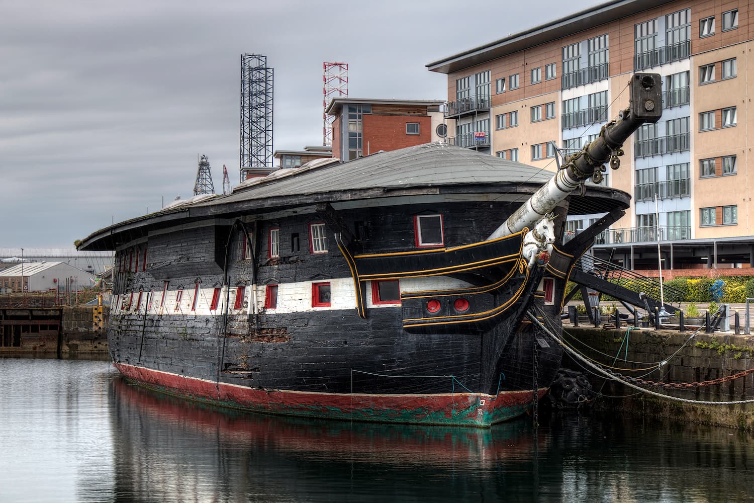 HMS Unicorn, a large ship, is docked in a harbour.