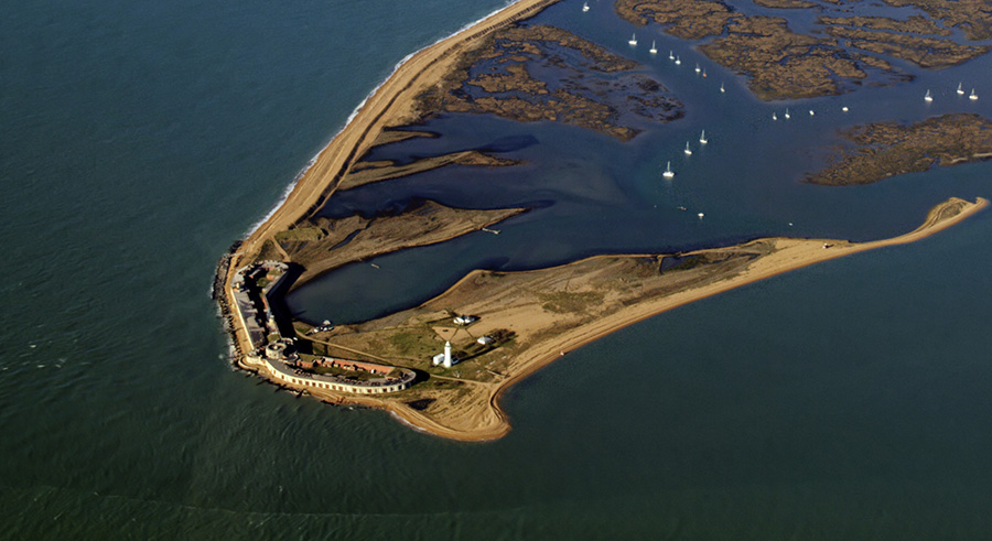 Elevated photo of large, long building on coastal spit