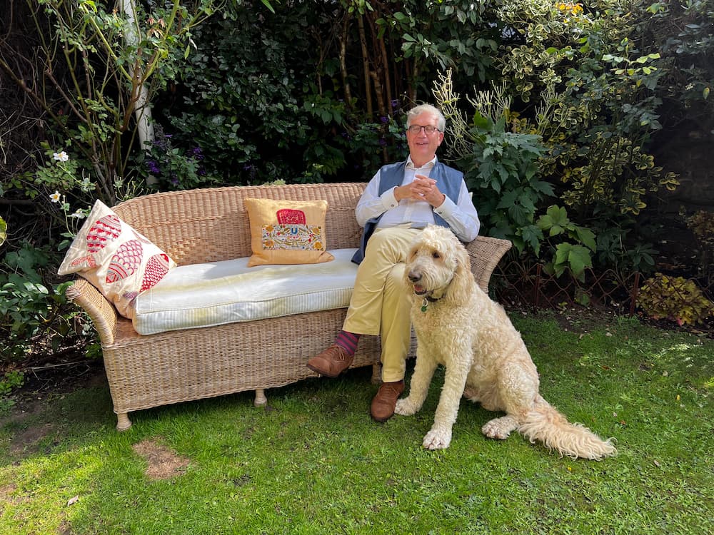Jamie Korner is sat on a sofa outside with his dog