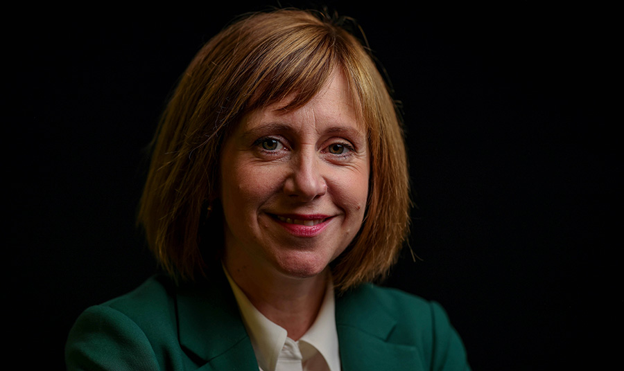 Head and shoulders portrait of Roisha Hughes with black background