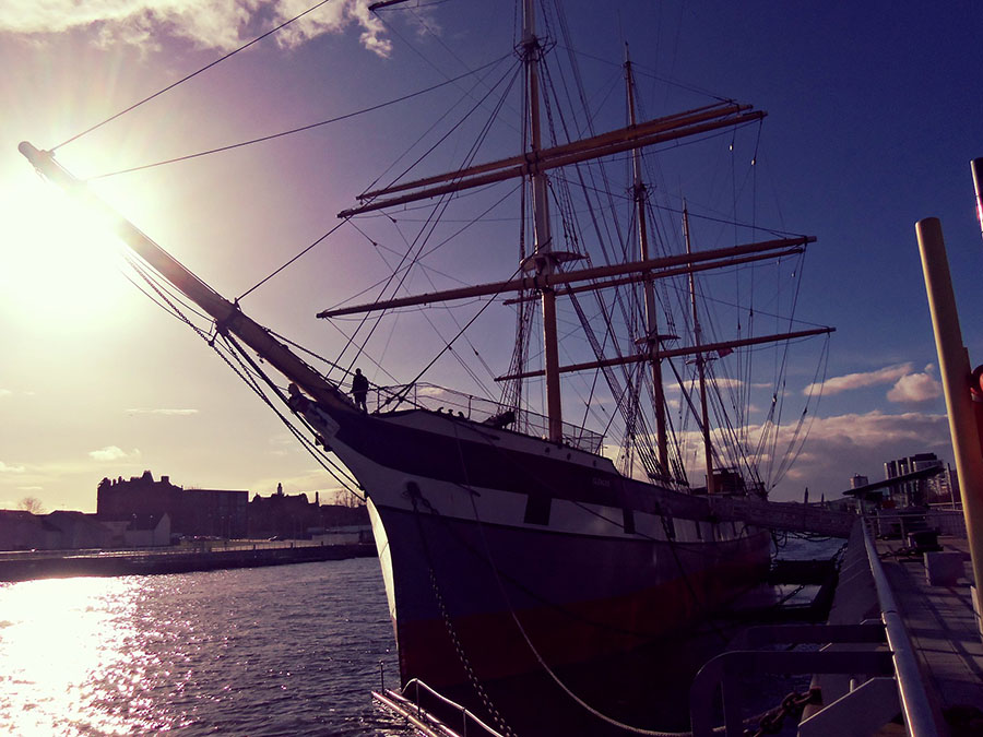 A ship berthed with the sun setting behind