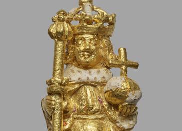 A close up of a gold figure of Henry VI holding a sceptre and orb